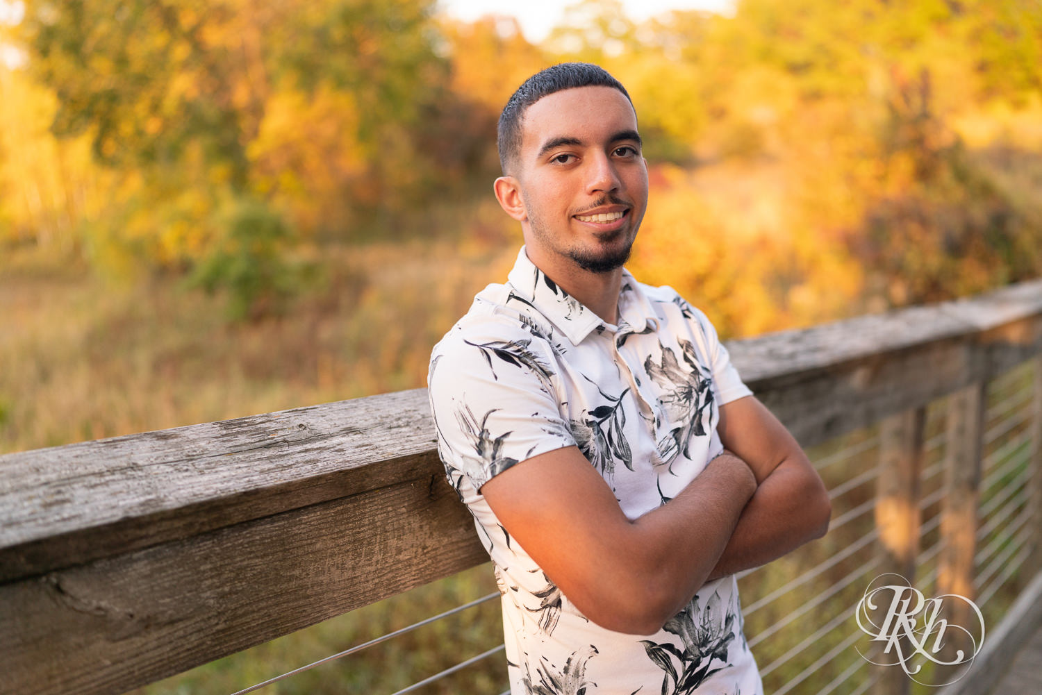 Black senior boy smiles during senior sunset photography in Eagan, Minnesota.