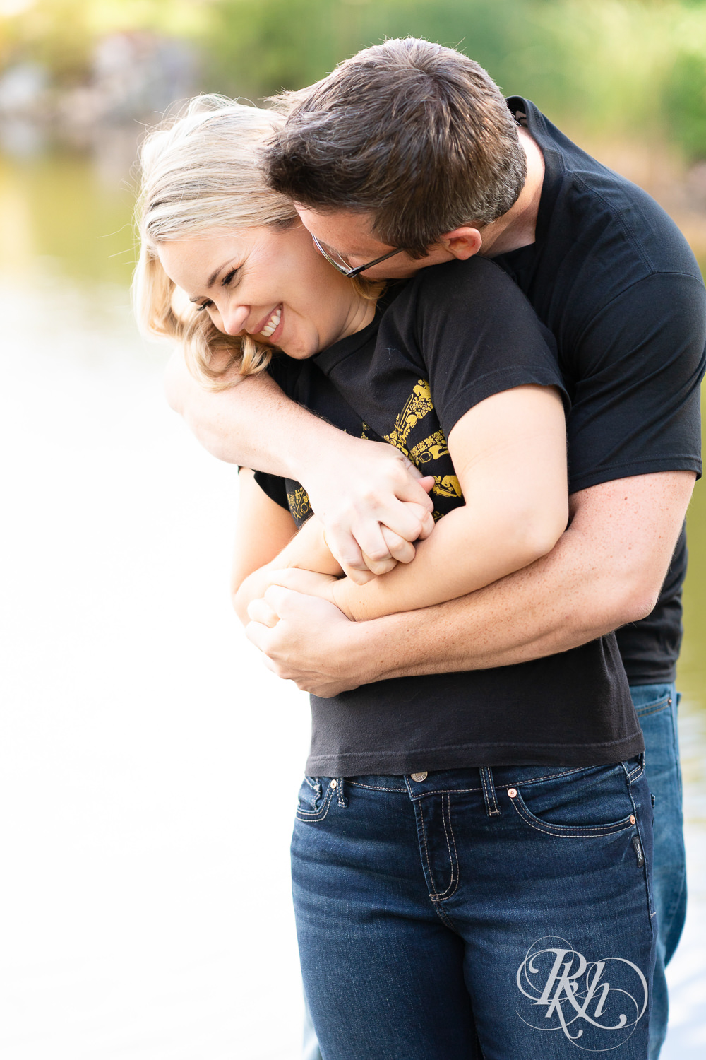 Man and woman in Zelda shirts snuggle during engagement photography at Centennial Lakes Park in Edina, Minnesota.