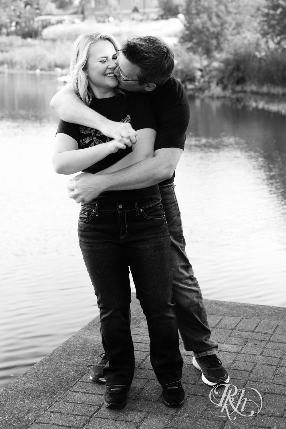 Man and woman in Zelda shirts snuggle during engagement photography at Centennial Lakes Park in Edina, Minnesota.