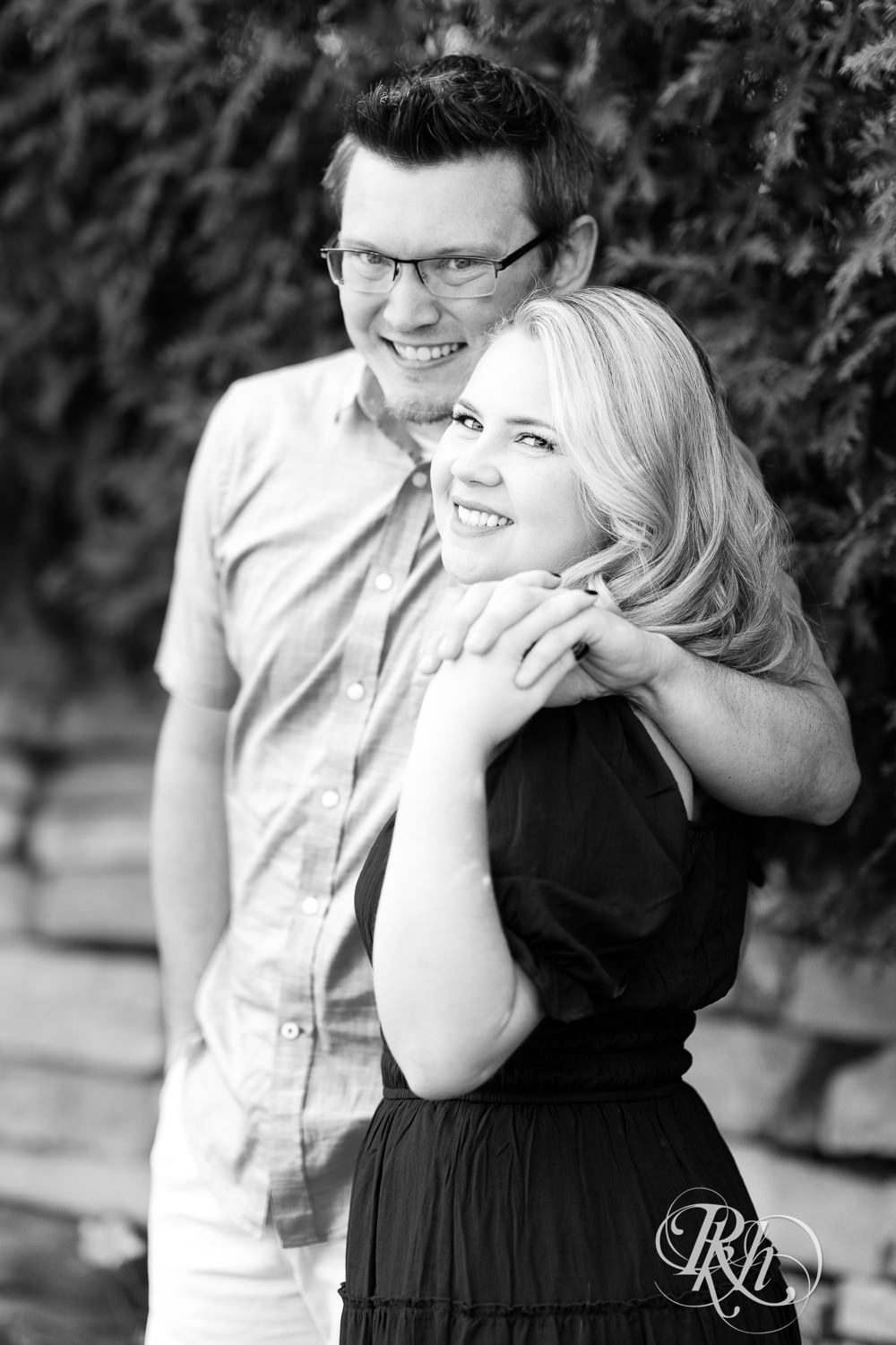 Man and woman in blue dress smile during morning engagement photography at Centennial Lakes Park in Edina, Minnesota.