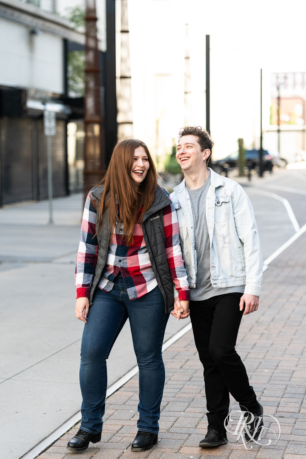 Man and woman in flannel laugh while walking down the street in Minneapolis, Minnesota.