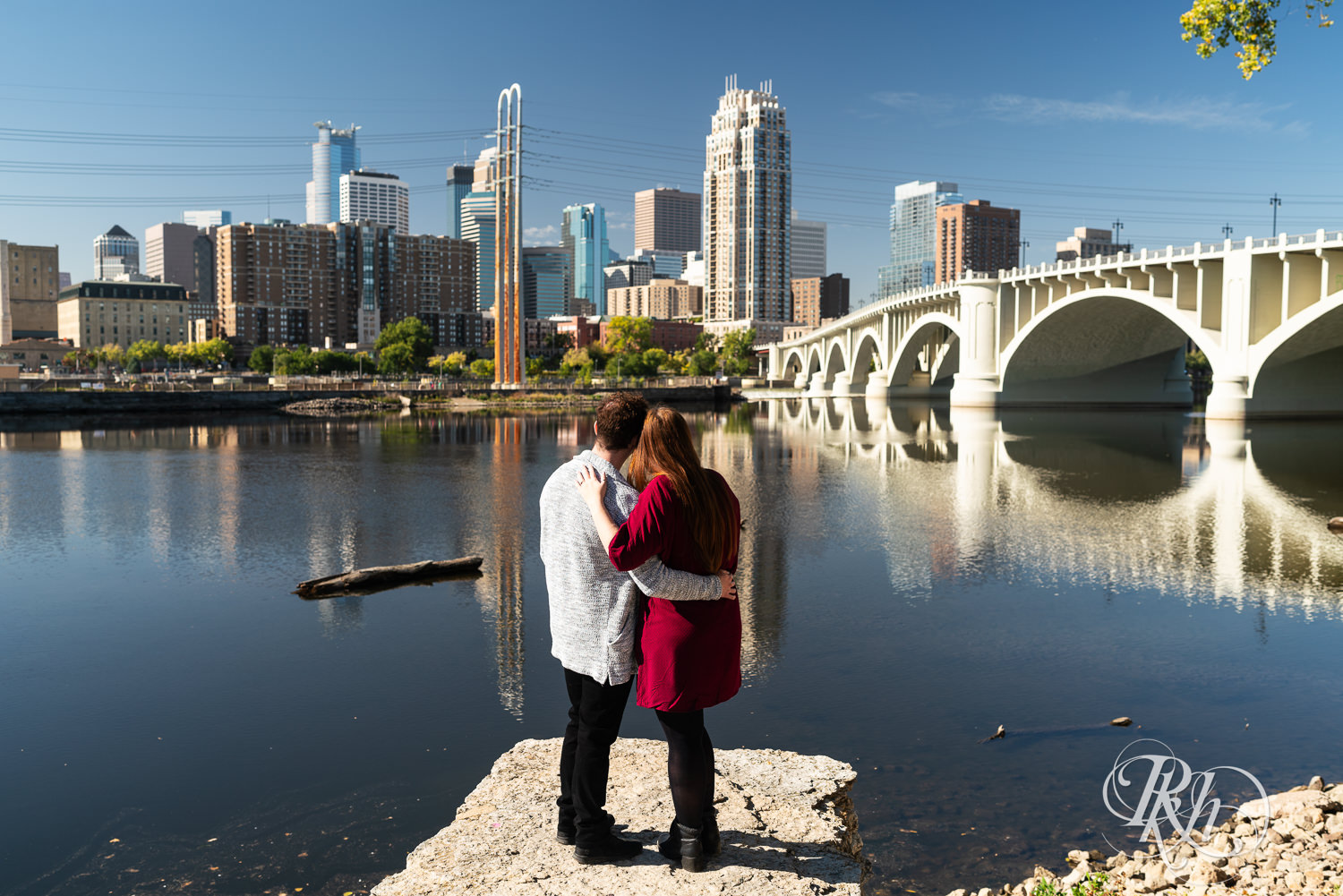 Man and woman in red dress look at the skyline in Minneapolis, Minnesota.