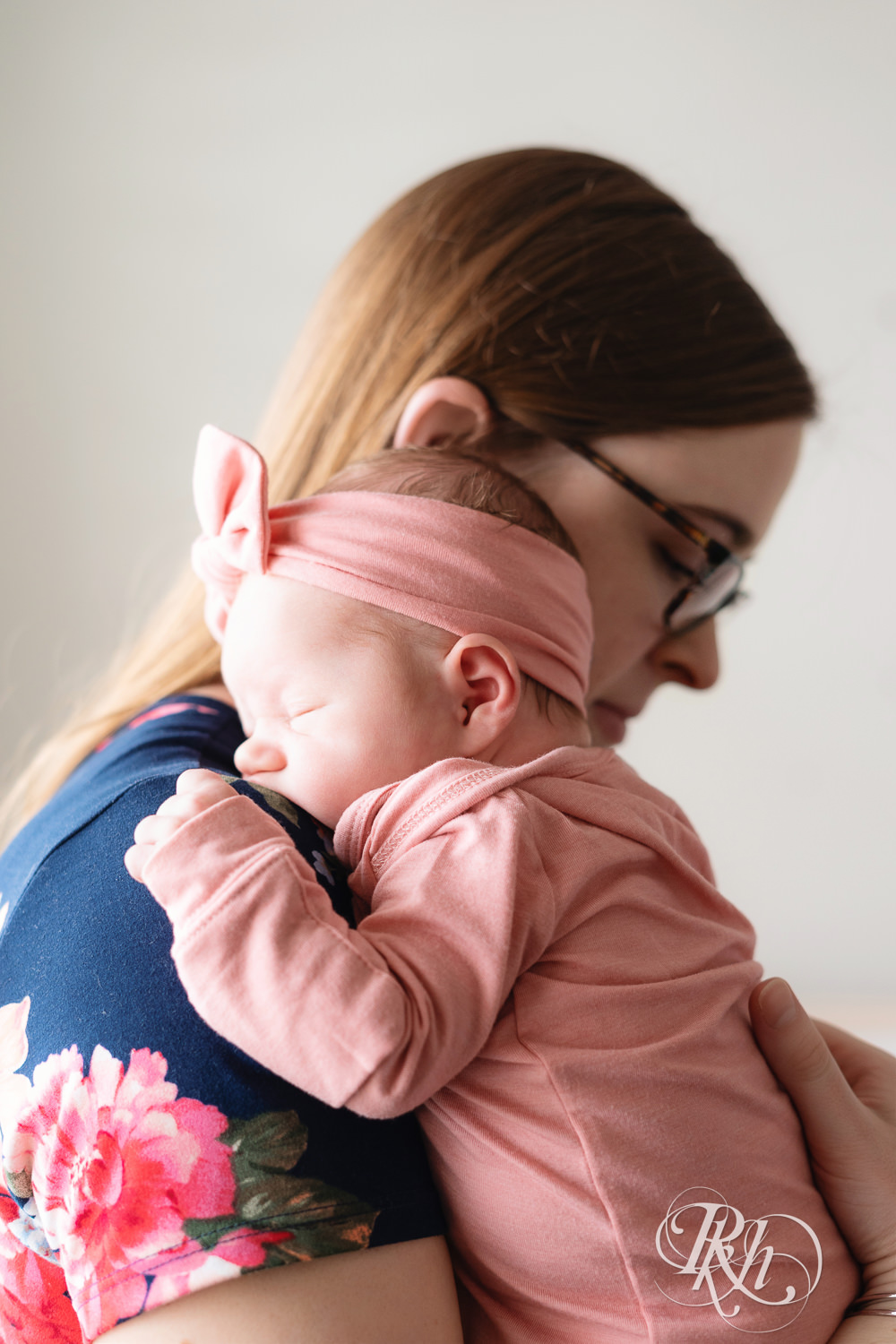 Mom holds newborn baby against her shoulder at home in Lakeville, Minnesota.