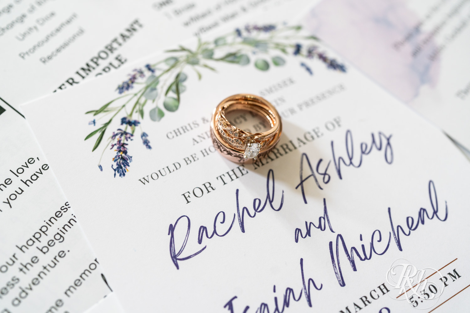 Wedding ring sits on the wedding invitation.