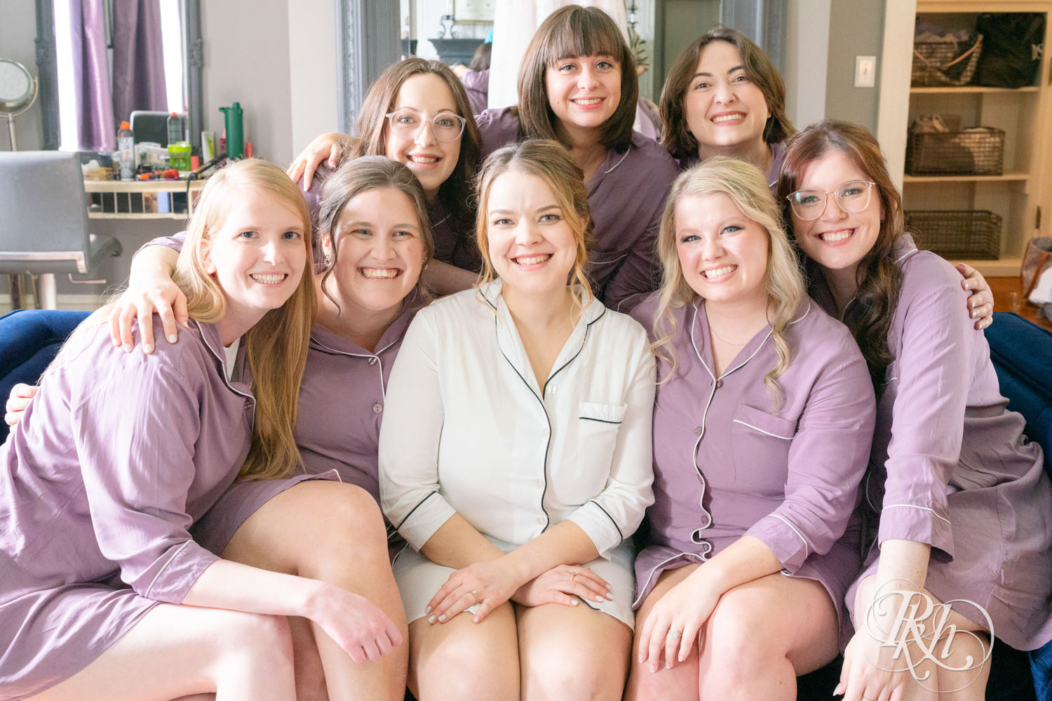 Bridesmaids snuggle with bride on the couch at the Semple Mansion in Minneapolis, Minnesota.