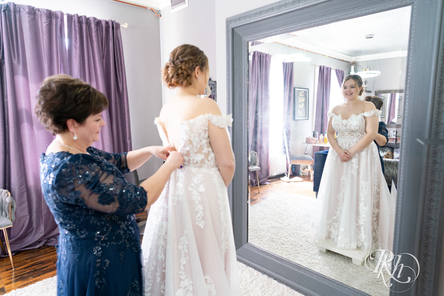 Mom helps bride get into wedding dress on wedding day at the Semple Mansion in Minneapolis, Minnesota.