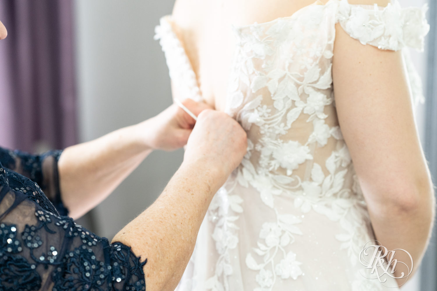Mom helps bride get into wedding dress on wedding day at the Semple Mansion in Minneapolis, Minnesota.