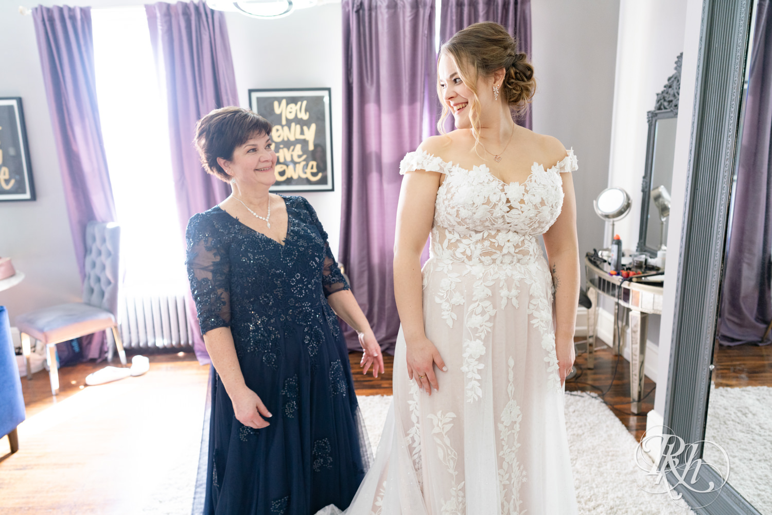 Mom helps bride get into wedding dress on wedding day at the Semple Mansion in Minneapolis, Minnesota.