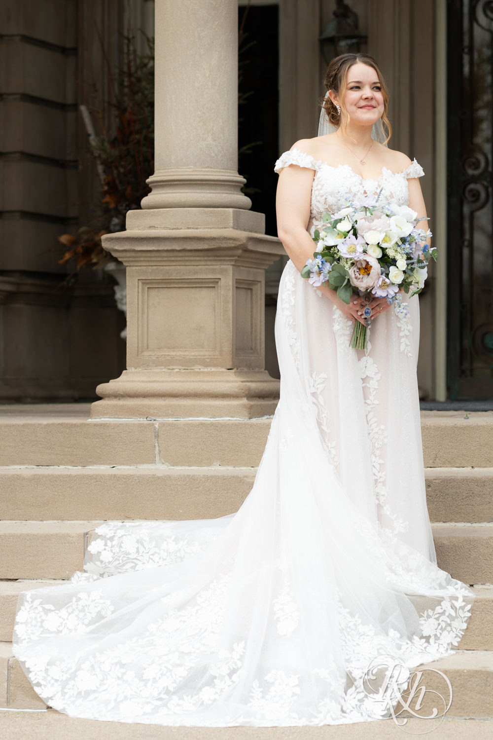 Bride stands on mansion stairs on their wedding day at the Semple Mansion in Minneapolis, Minnesota.