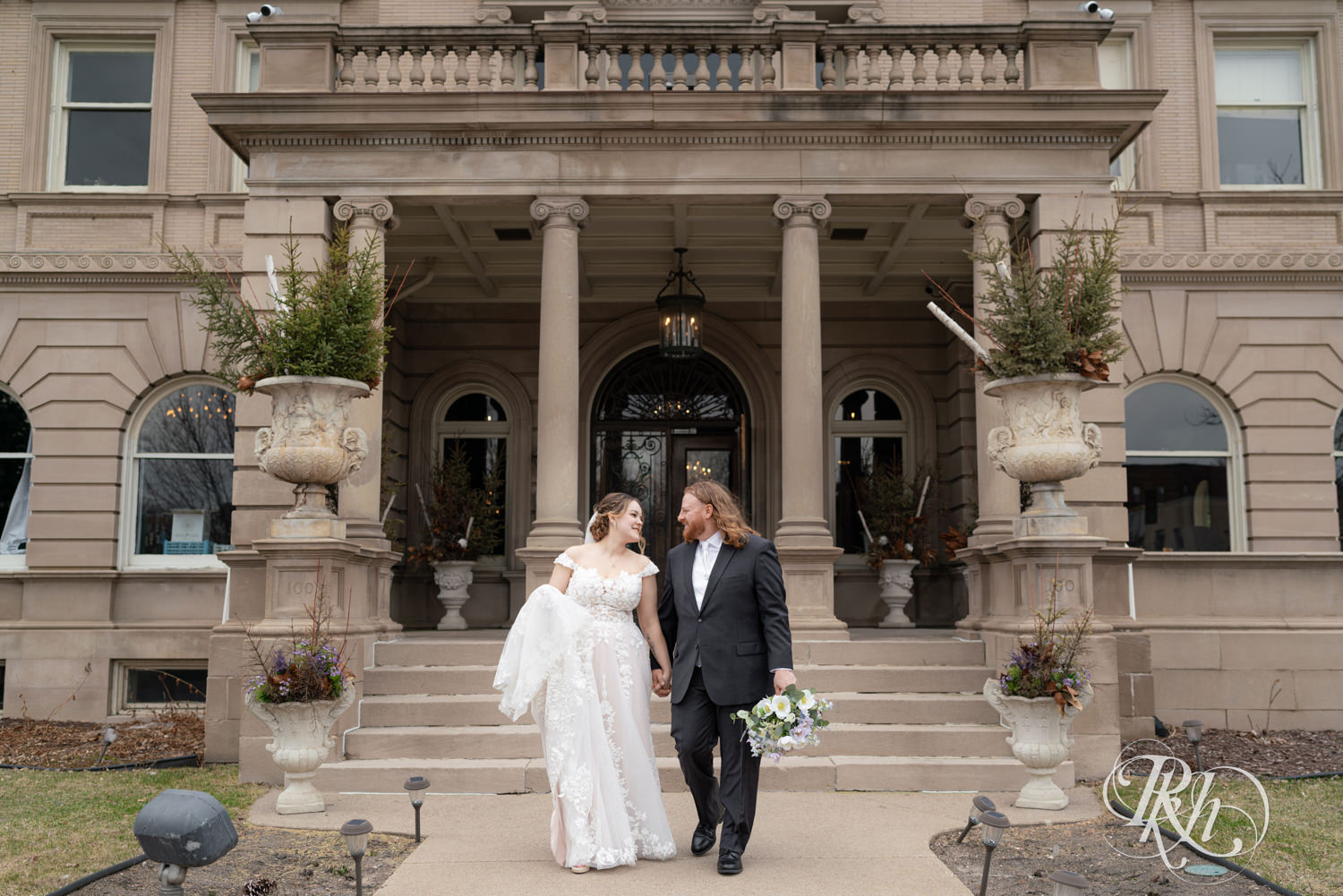 Bride and groom walk and smile at the Semple Mansion in Minneapolis, Minnesota.