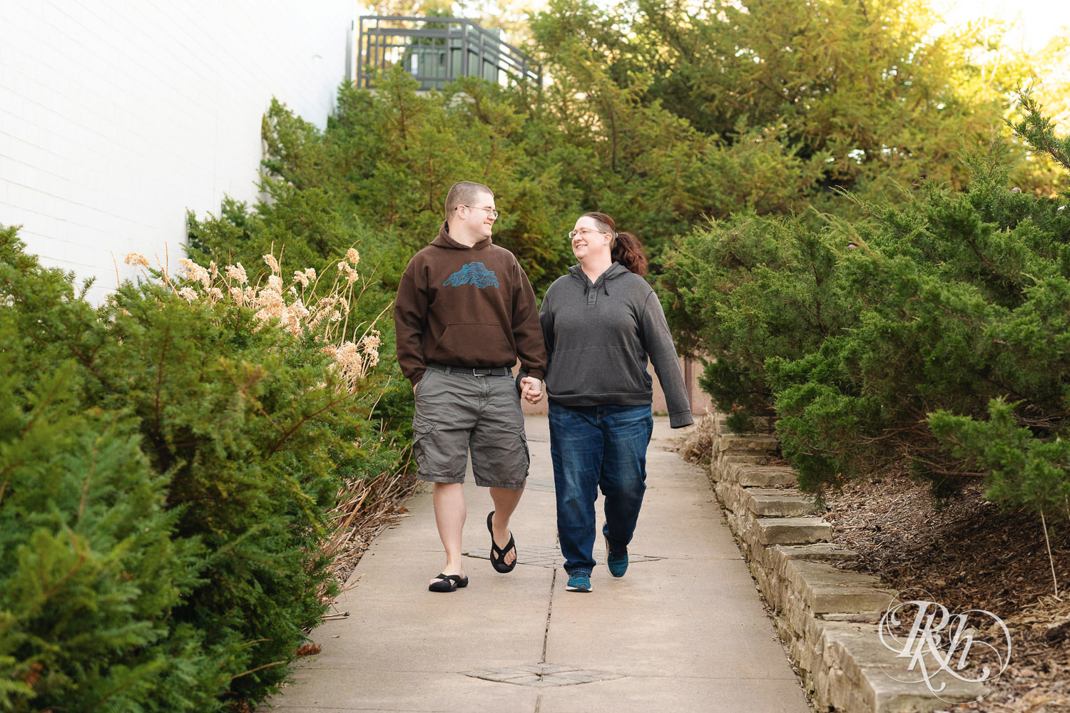 Man and woman in sweatshirts walk down path at Centennial Lakes Park in Edina, Minnesota.