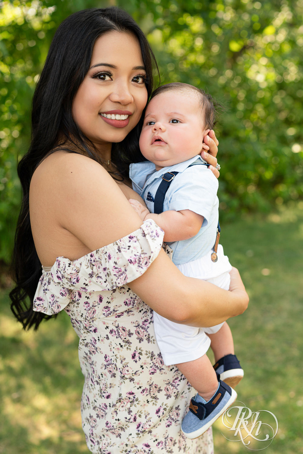 Woman in floral dress smiles with her baby at Lebanon Hills Regional Park in Eagan, Minnesota.