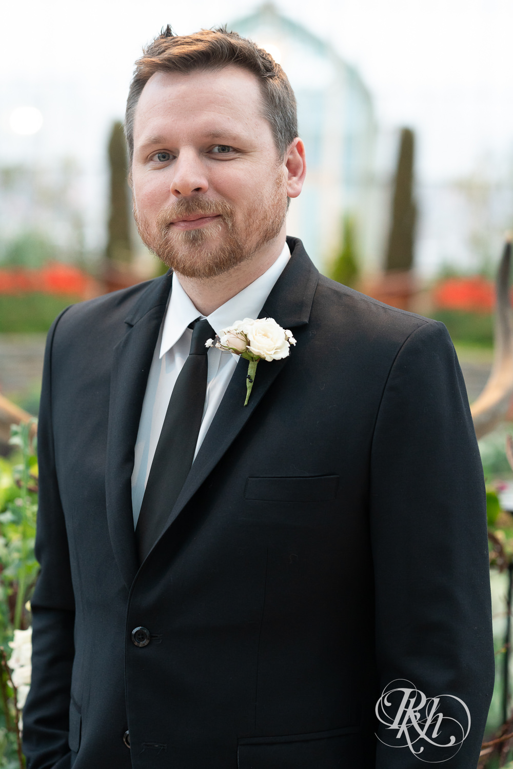 Groom smiles on wedding day at the Sunken Garden at the Como Zoo and Conservatory in Saint Paul, Minnesota.