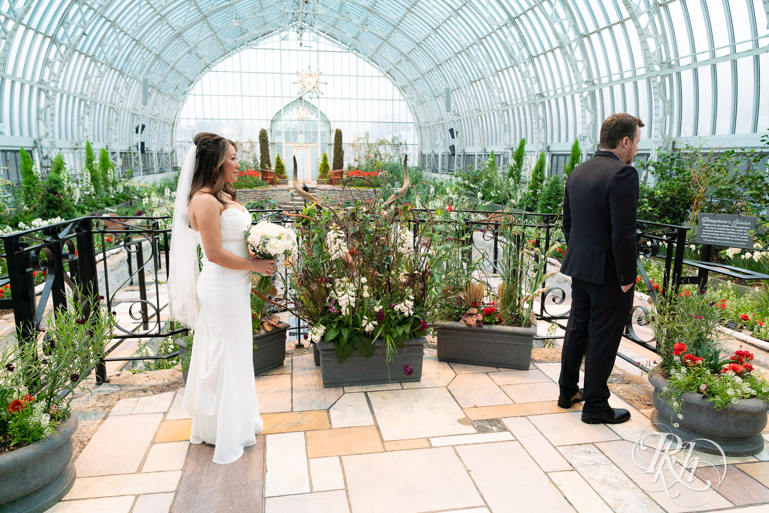Asian bride and groom share first look on wedding day at the Sunken Garden at the Como Zoo and Conservatory in Saint Paul, Minnesota.