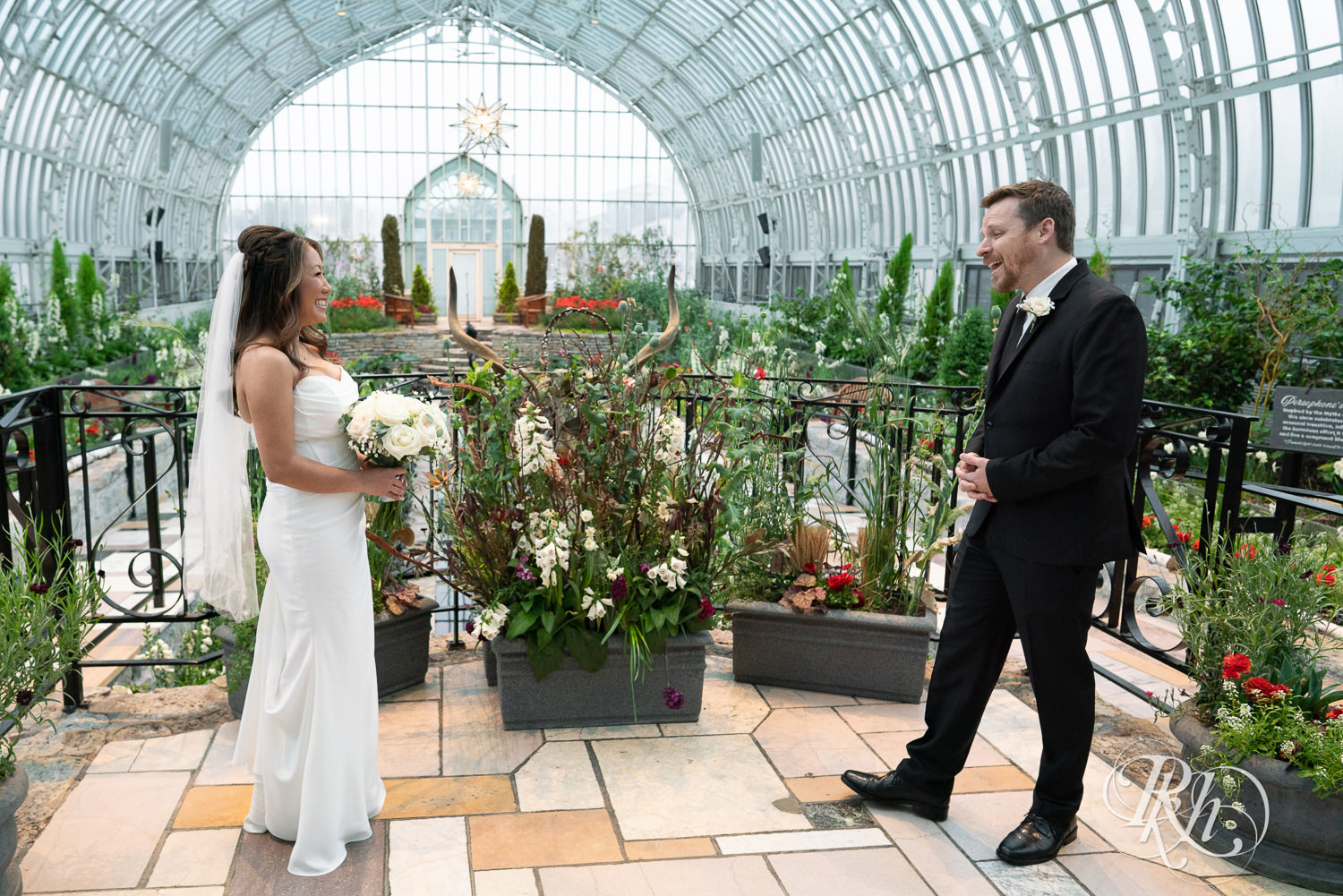 Asian bride and groom share first look on wedding day at the Sunken Garden at the Como Zoo and Conservatory in Saint Paul, Minnesota.