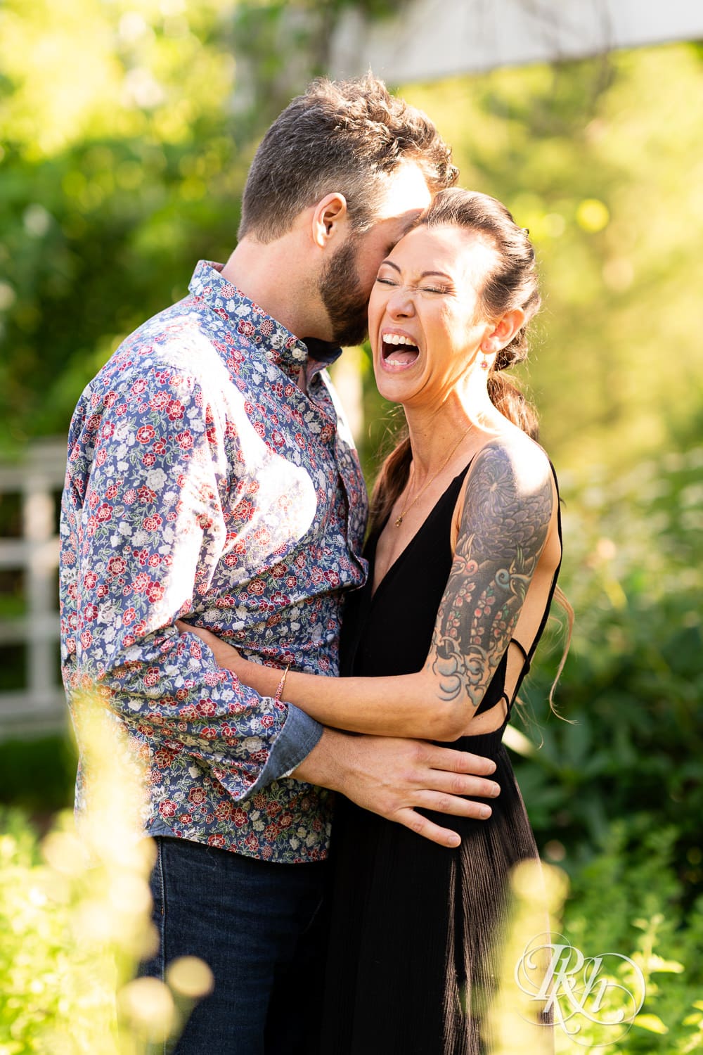 Man and woman kiss in the sunlight at the Minnesota Landscape Arboretum in Chaska, Minnesota.
