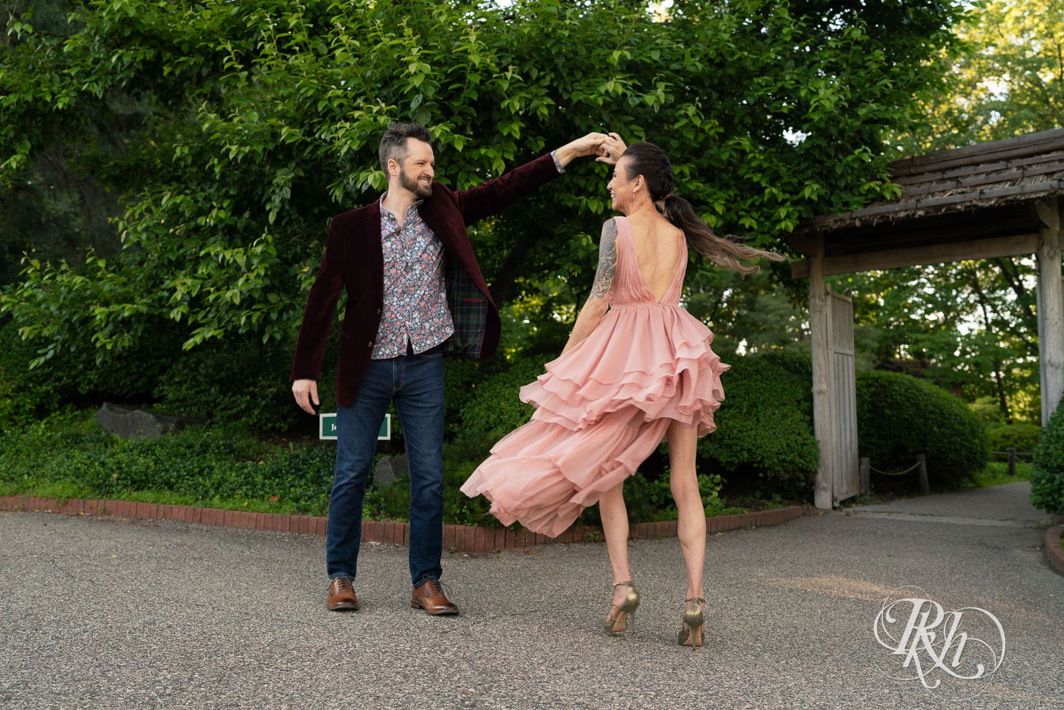 Man in red velvet jacket and woman in pink dress dance at the Minnesota Landscape Arboretum in Chaska, Minnesota.